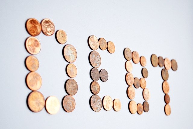 The word debt written with coins