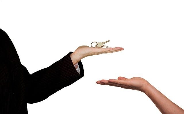 A seller giving the buyer the keys to the house after closing a seller financing deal