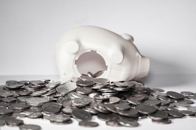 A broken piggy bank with coins pouring out