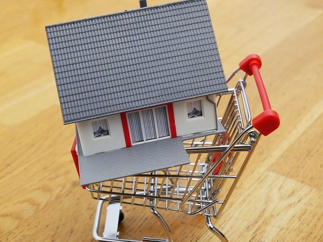 A miniature house in a shopping cart symbolizing a listed property