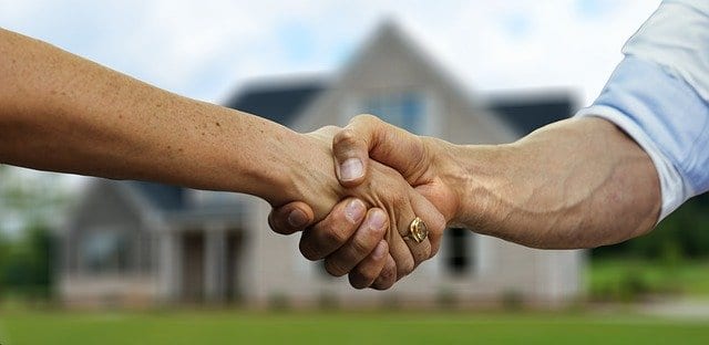 An homeowner shaking the hands of an investor after selling their property to the investor
