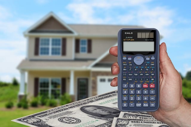 A person using a calculator to find out how much it will costs to buy a house