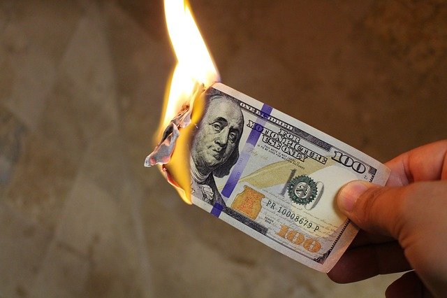 A burning dollar notes representing how homeowners who are not smart with finances waste money during pre-foreclosure