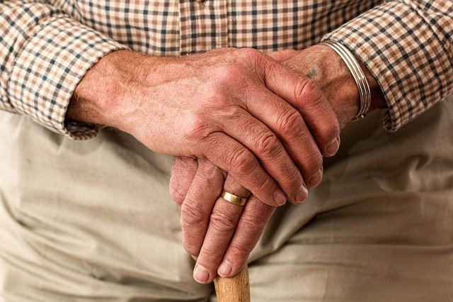 An old man hands holding a staff