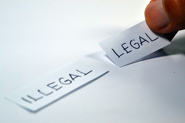Two piece of papers with "illegal" and "legal" written on it